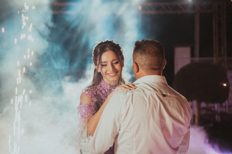 Happy couple dancing at wedding reception with joyful expressions.