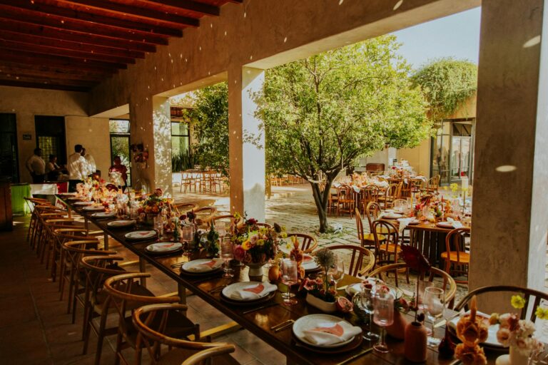 Beautiful outdoor wedding reception with decorated tables and lush greenery.