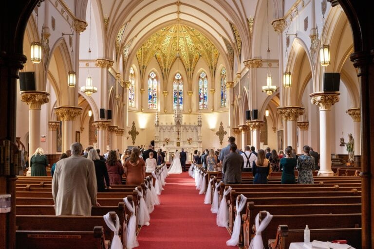 Church wedding ceremony with guests and ornate architecture.