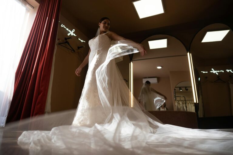 Bride in elegant wedding gown spinning in front of mirror.