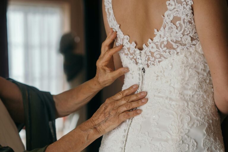 Bride's lace wedding dress being adjusted by a tailor in Fontainebleau.
