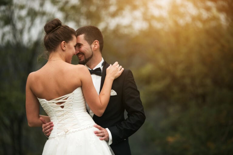 Bride and groom sharing a joyful moment in a romantic outdoor setting.