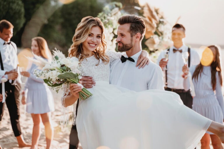 Bride and groom smiling, bride holding a bouquet, wedding celebration.