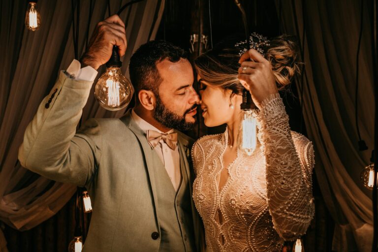 Romantic wedding couple sharing a tender moment with vintage lighting ambiance.